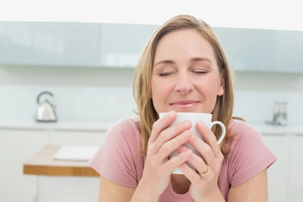 Närbild av en avslappnad kvinna med kaffe i köket — Stockfoto