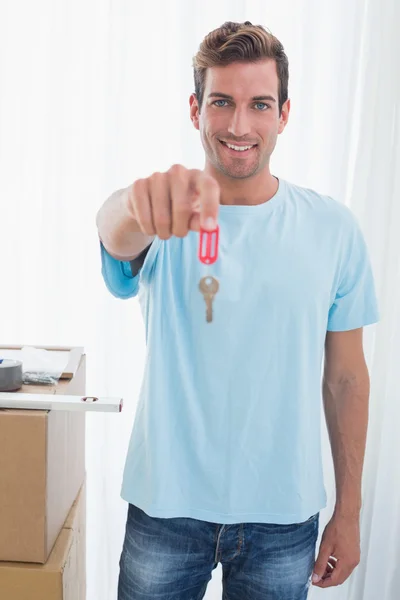 Uomo felice tenendo fuori la nuova chiave di casa — Foto Stock