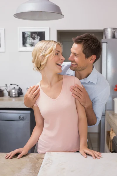 Feliz amante joven pareja en la cocina — Foto de Stock