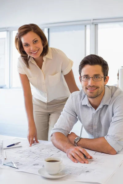 Two colleagues working on blueprints at office — Stock Photo, Image