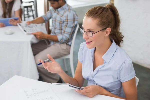 Mujer sonriente con notas en la cafetería — Foto de Stock