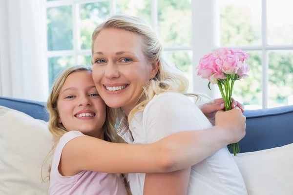 Girl with roses embracing mother — Stock Photo, Image