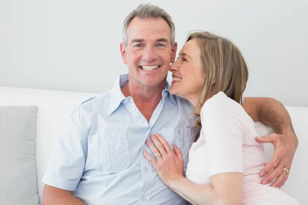 Portrait of a happy couple embracing in living room — Stock Photo, Image