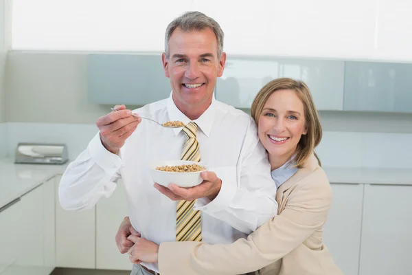 Mujer abrazando al hombre mientras desayuna en la cocina — Foto de Stock