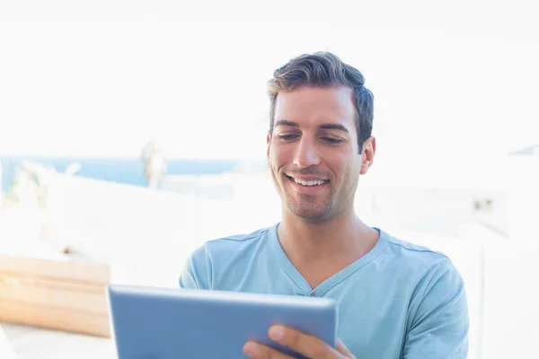 Usmívající se muž doma pomocí digitálních tabletu — Stock fotografie