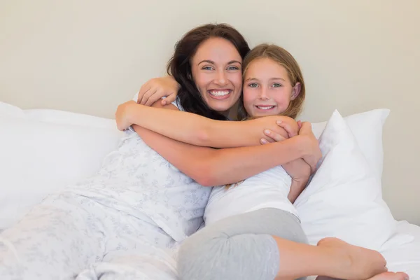 Matka a dcera objímat v posteli — Stock fotografie