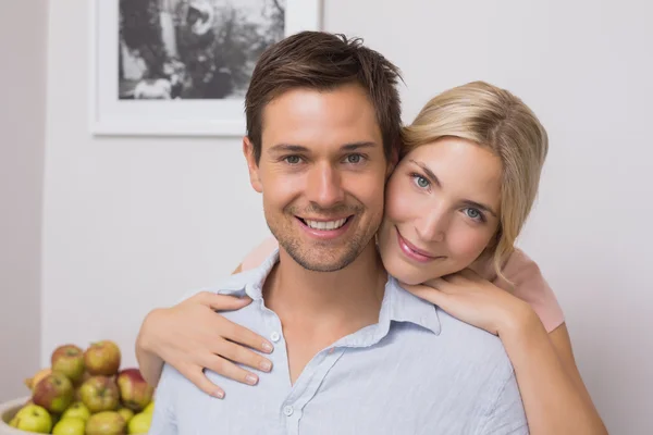 Woman embracing man from behind at home — Stock Photo, Image