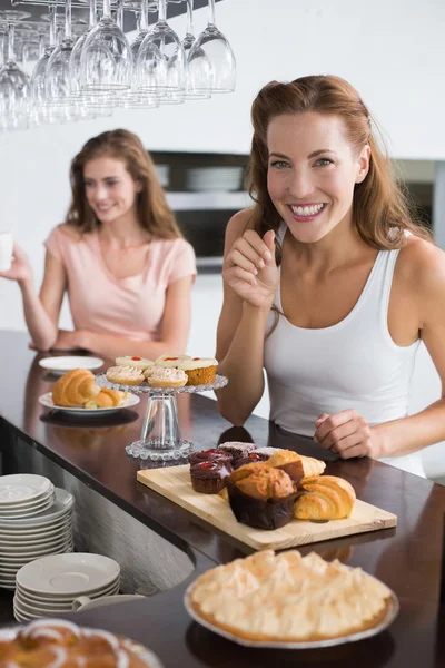 Mujer sonriente con comida dulce en la cafetería —  Fotos de Stock