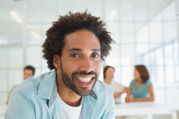 Smiling businessman with colleagues in meeting — Stock Photo, Image