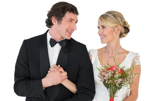 Braut und Bräutigam halten Händchen, während sie einander anschauen — Stockfoto