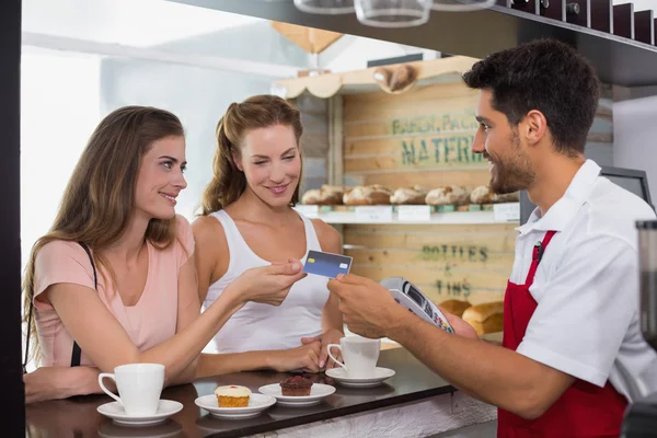 Przyjaciele z kobiety domagają się kart kredytowych w kawiarnia — Zdjęcie stockowe