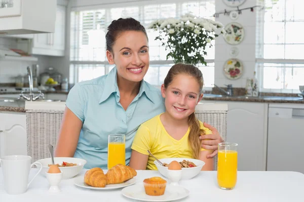 Matka a dcera sedí u stolu se snídaní — Stock fotografie