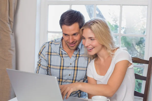 Casal sorrindo usando laptop na cozinha — Fotografia de Stock