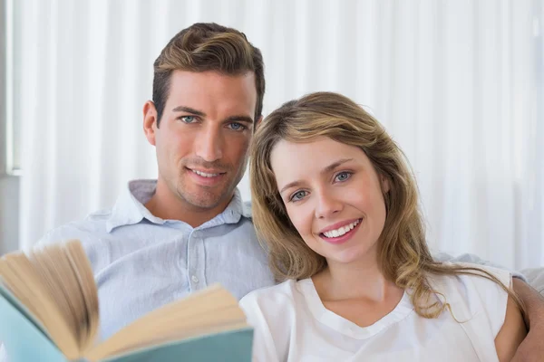 Relaxed young couple reading book at home — Stock Photo, Image