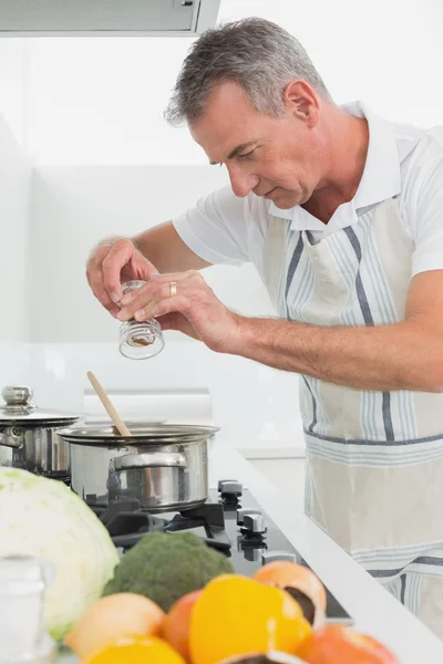Вид сбоку на человека, который готовит еду на кухне — стоковое фото