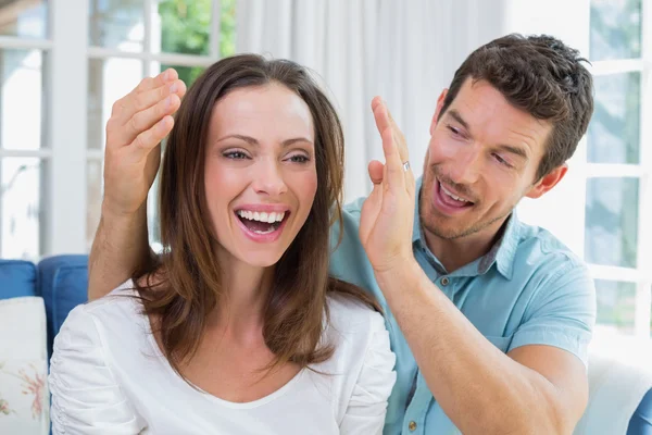 Young man surprising woman in the living room — Stock Photo, Image