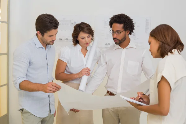 Business colleagues working on blueprints at office — Stock Photo, Image
