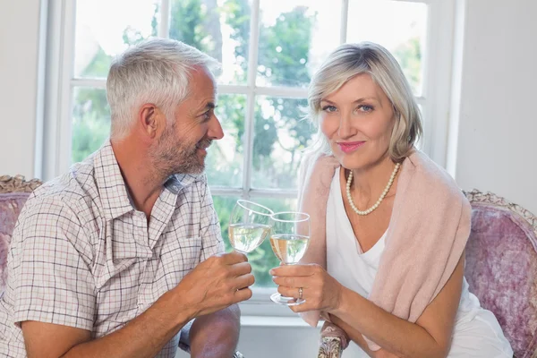 Happy mature couple with wine glasses at home — Stock Photo, Image