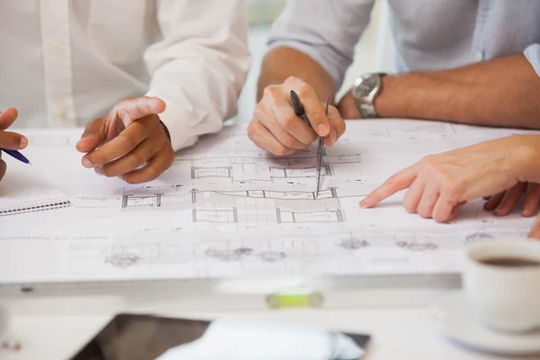 Mid section of business people working on blueprints — Stock Photo, Image