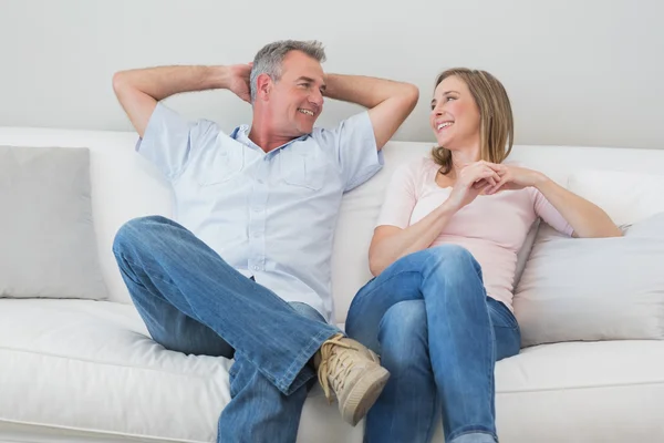 Happy relaxed couple sitting on sofa — Stock Photo, Image
