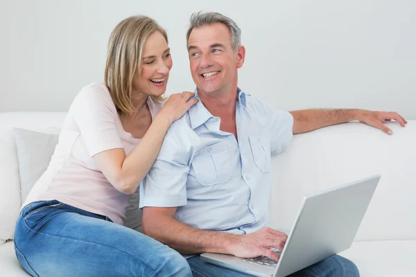 Pareja relajada usando portátil en casa —  Fotos de Stock