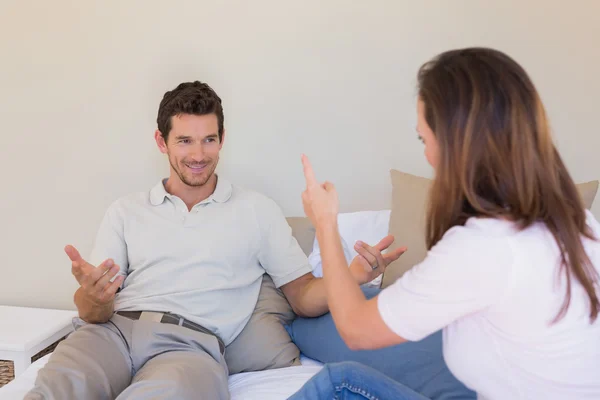 Cheerful couple having a conversation in bedroom — Stock Photo, Image