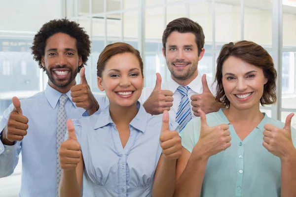 Business colleagues gesturing thumbs up — Stock Photo, Image