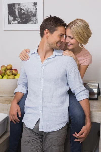 Mujer sonriente abrazando al hombre desde atrás en casa — Foto de Stock