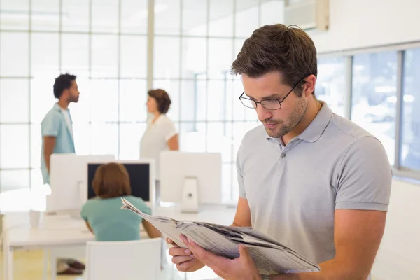 Zakenman krant lezen met collega's in de vergadering — Stockfoto