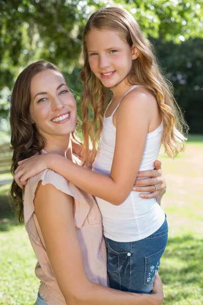 Portrait of a smiling girl and mother at park — Stock Photo, Image