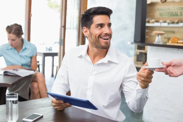 Man tar emot kaffe när du använder digital tablet i kafé — Stockfoto