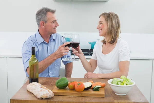 Amor pareja tostando copas de vino en la cocina —  Fotos de Stock