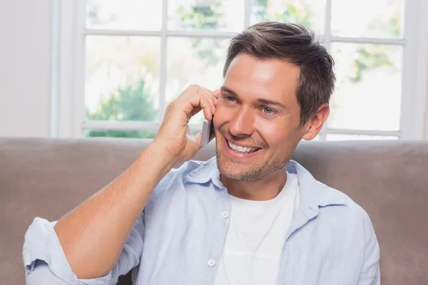 Casual man using mobile phone on sofa — Stock Photo, Image