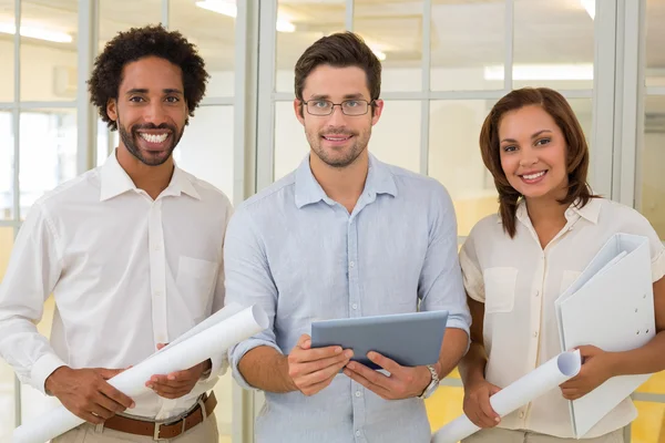 Business colleagues with blueprints and digital tablet in office — Stock Photo, Image