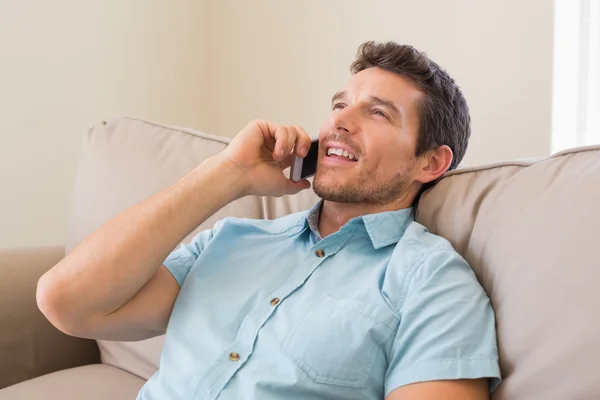 Avslappnad man använder mobiltelefon i vardagsrum — Stockfoto