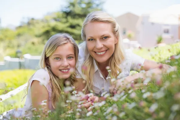 Gelukkig moeder en dochter liggen in park — Stockfoto