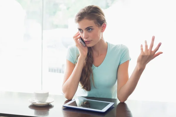 Mulher com xícara de café usando tablet digital e celular no café — Fotografia de Stock