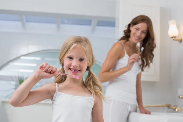 Chica con madre cepillarse los dientes en el baño — Foto de Stock