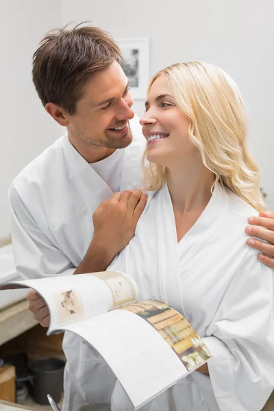 Pareja feliz con libro de recetas mirándose en la cocina —  Fotos de Stock