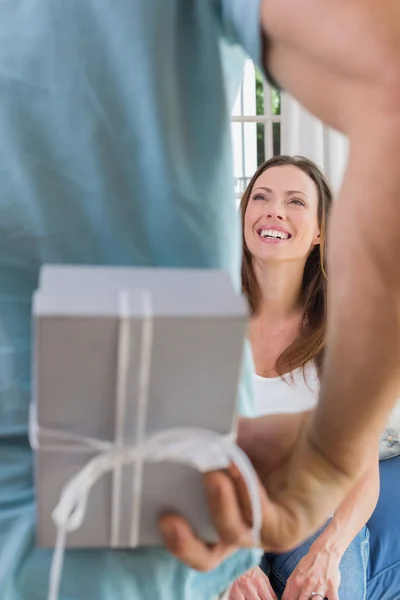 Man surprising a happy woman with gift box — Stock Photo, Image