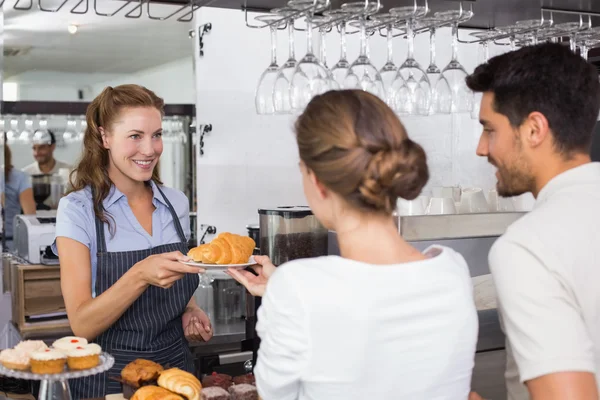 Waiter giving sweet food to a couple at coffee shop — Stock Photo, Image