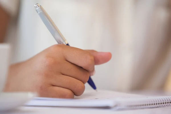 Mid sectie van een zakenvrouw schrijven in Kladblok — Stockfoto