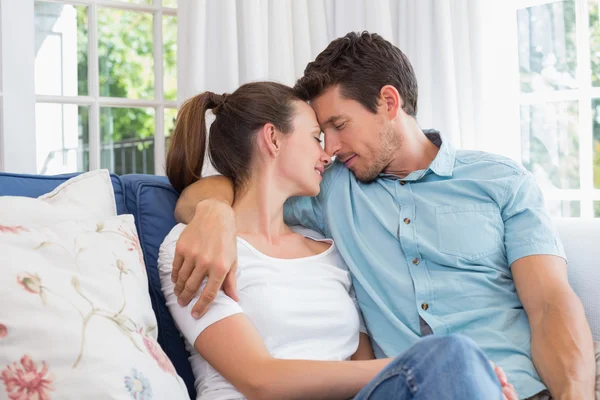 Liebendes junges Paar sitzt auf Couch — Stockfoto