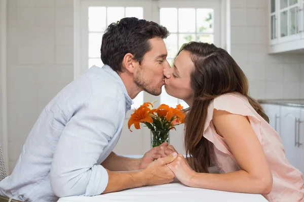 Zijaanzicht van een liefdevol paar zoenen in keuken — Stockfoto