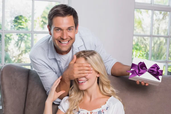 Young man surprising woman with a gift — Stock Photo, Image