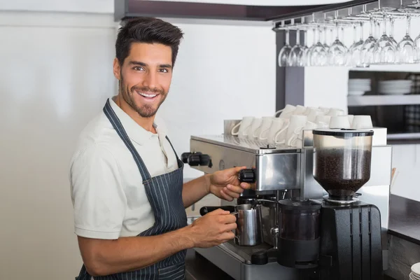 Garçom sorrindo e fazendo xícara de café no café — Fotografia de Stock