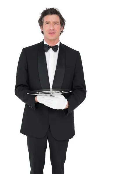 Waiter holding empty tray over white background — Stock Photo, Image