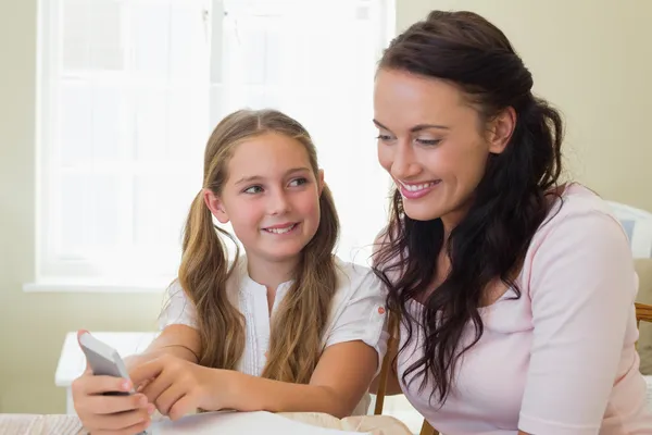 Chica mostrando el teléfono celular a la madre — Foto de Stock