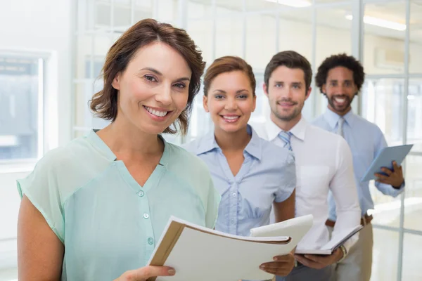 Business colleagues holding notepads in row at office — Stock Photo, Image