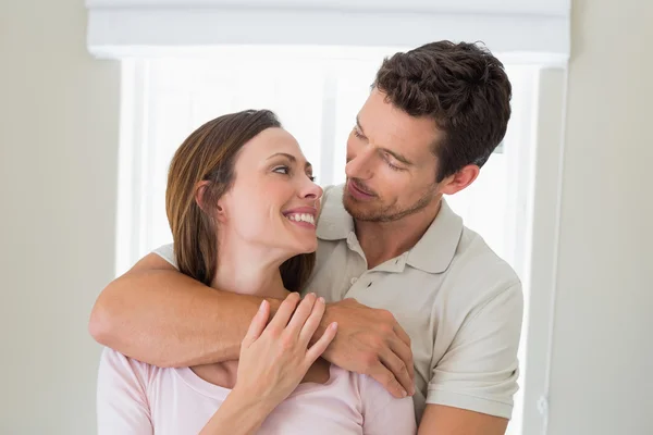 Amore uomo abbracciare donna da dietro a casa — Foto Stock